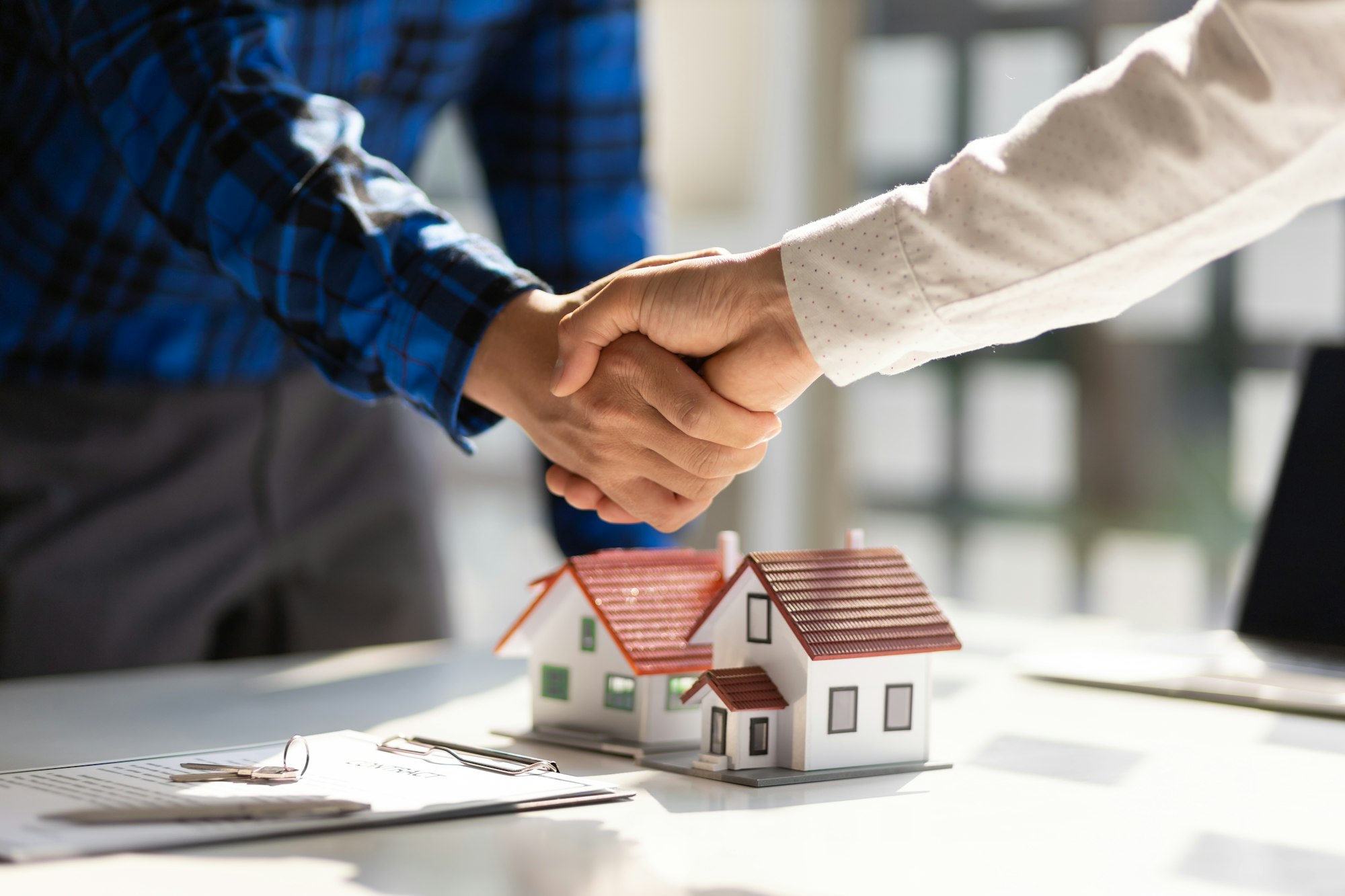 Real estate agents shake hands after the signing of the contract agreement is complete.