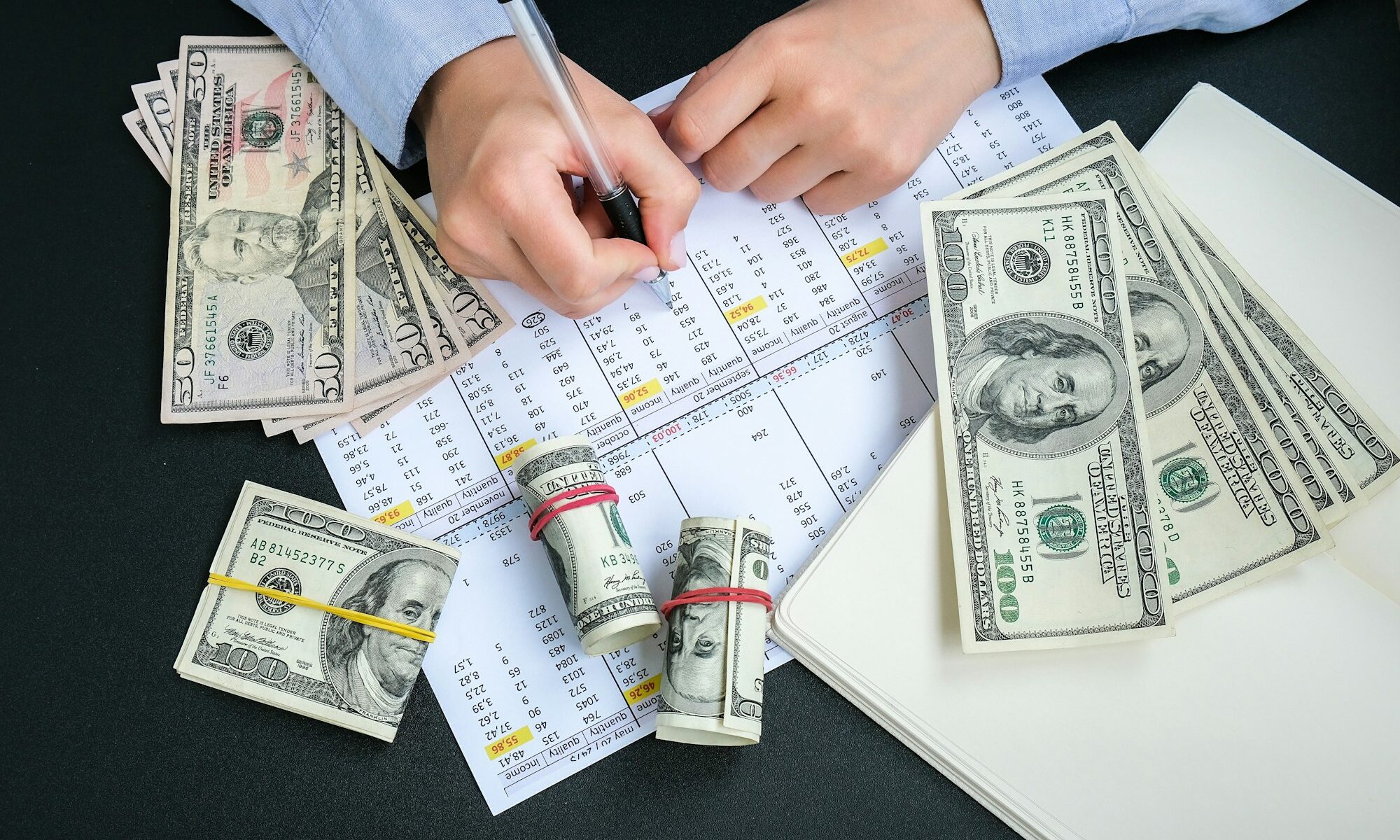 Working businesswoman hand at office workplace desk. Counting money for salary. Investment savings.