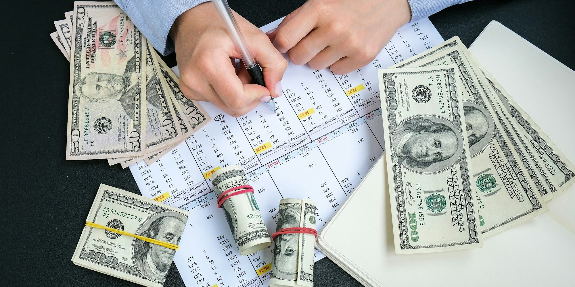 Working businesswoman hand at office workplace desk. Counting money for salary. Investment savings.